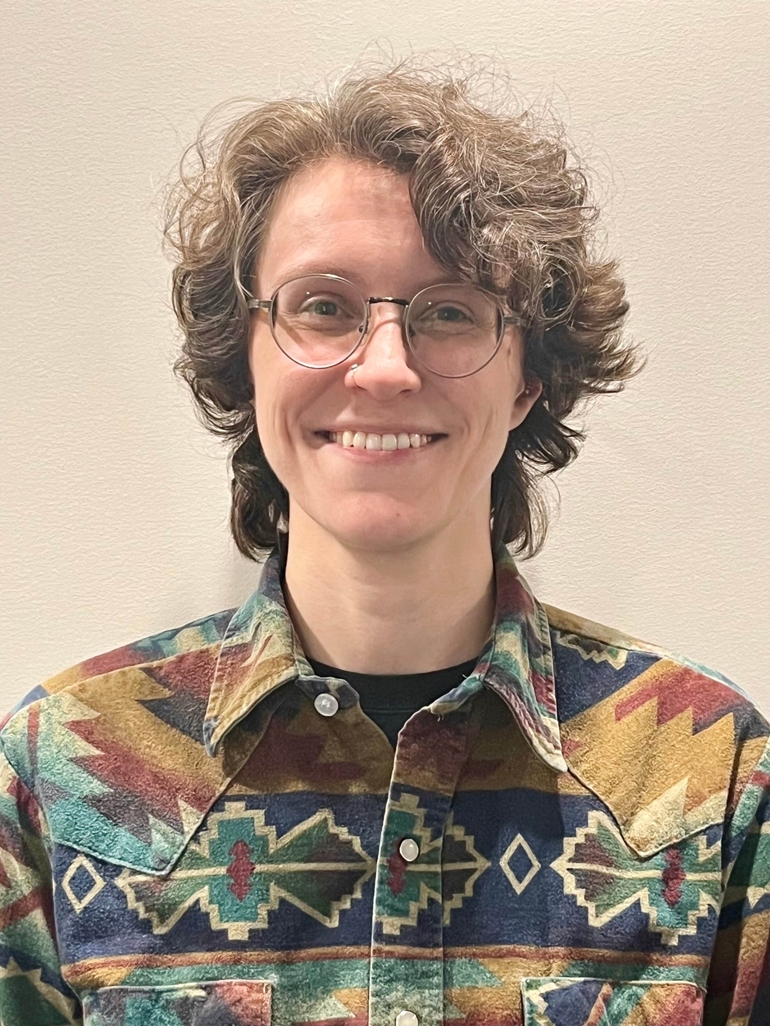 Portrait of Rachael Mannion, who has a light skin tone and short brown hair, is smiling.